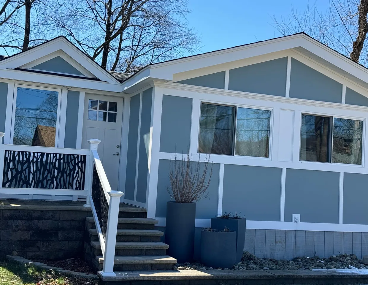 Slate-blue flat fiber cement panel cladding with a white batten grid by North Valley Exteriors