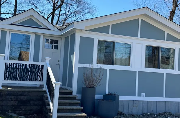 Slate-blue flat fiber cement panel cladding with a white batten grid by North Valley Exteriors