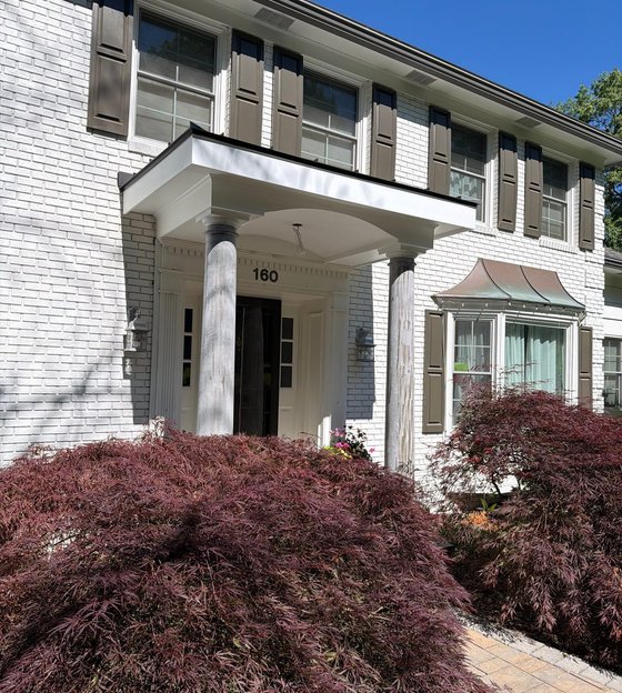 White brick colonial with a restored scroll portico, completed by North Valley Exteriors