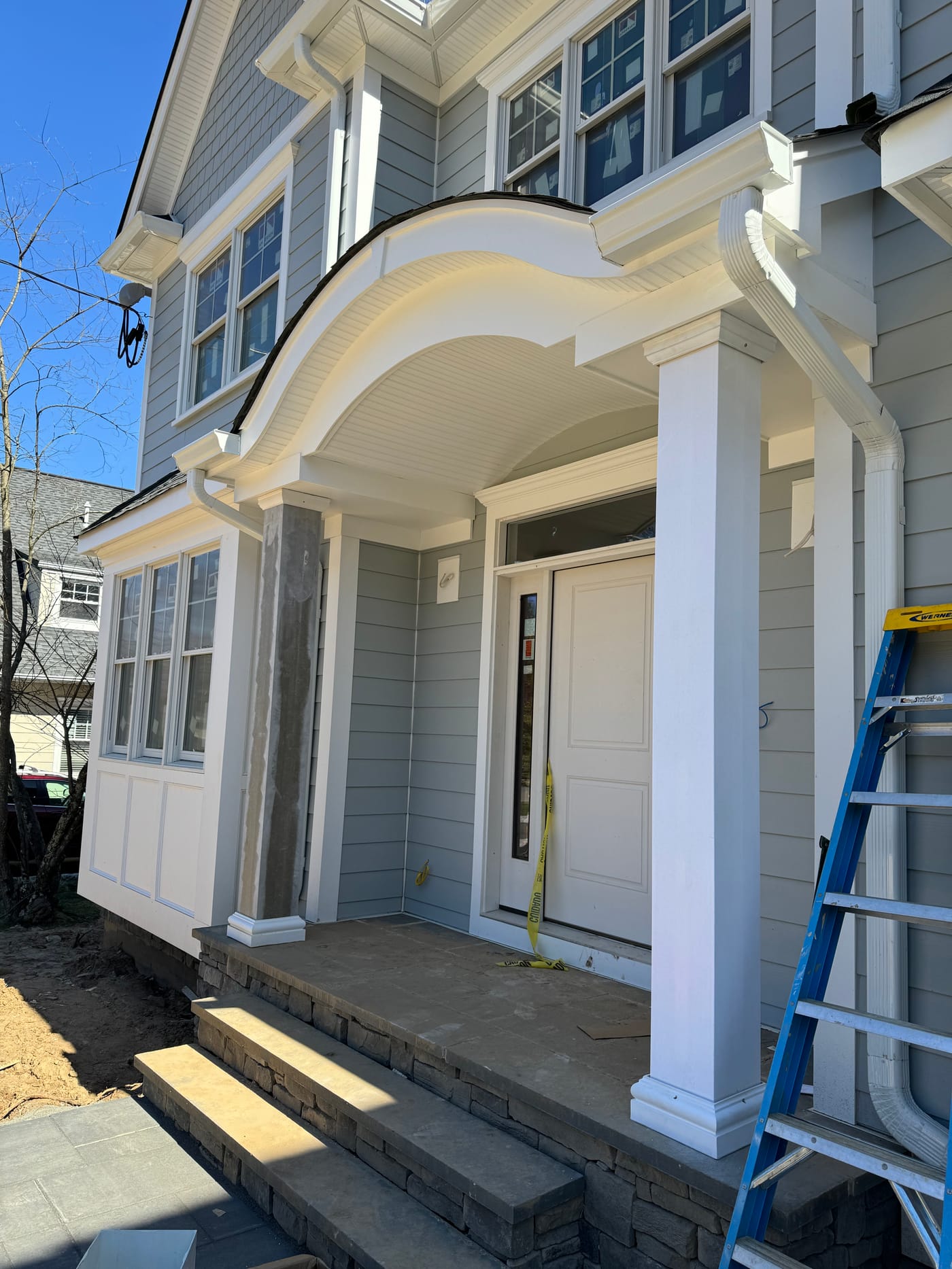 White scrolled portico with a fluted column and a beadboard ceiling