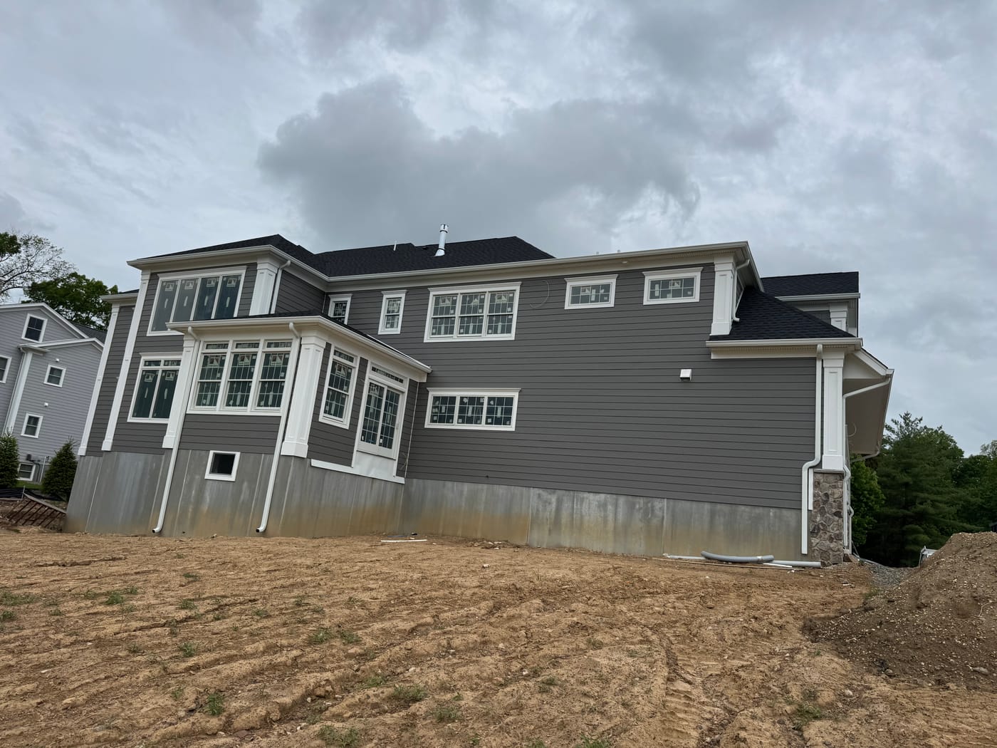 Rear elevation in gray HardiePlank lap with a box-bay window cluster