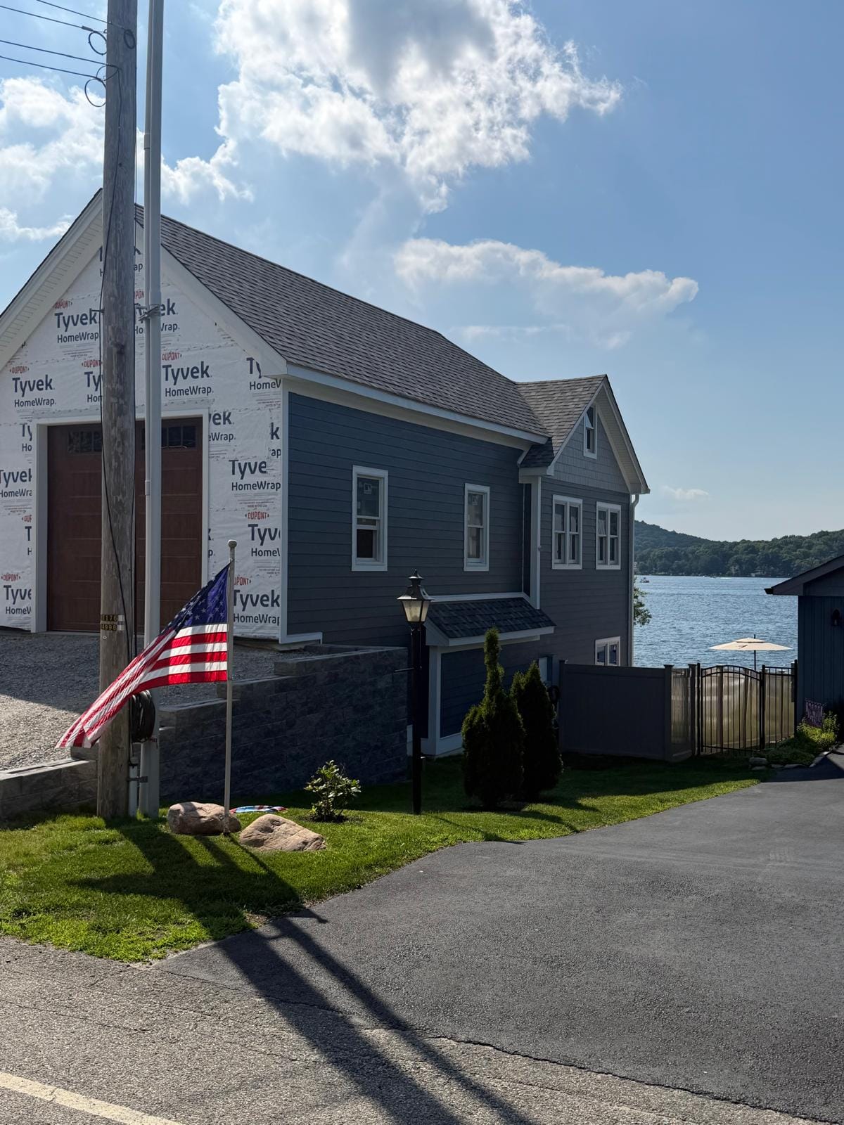 Finished navy HardiePlank lakefront home with a gray shake gable and a lake view