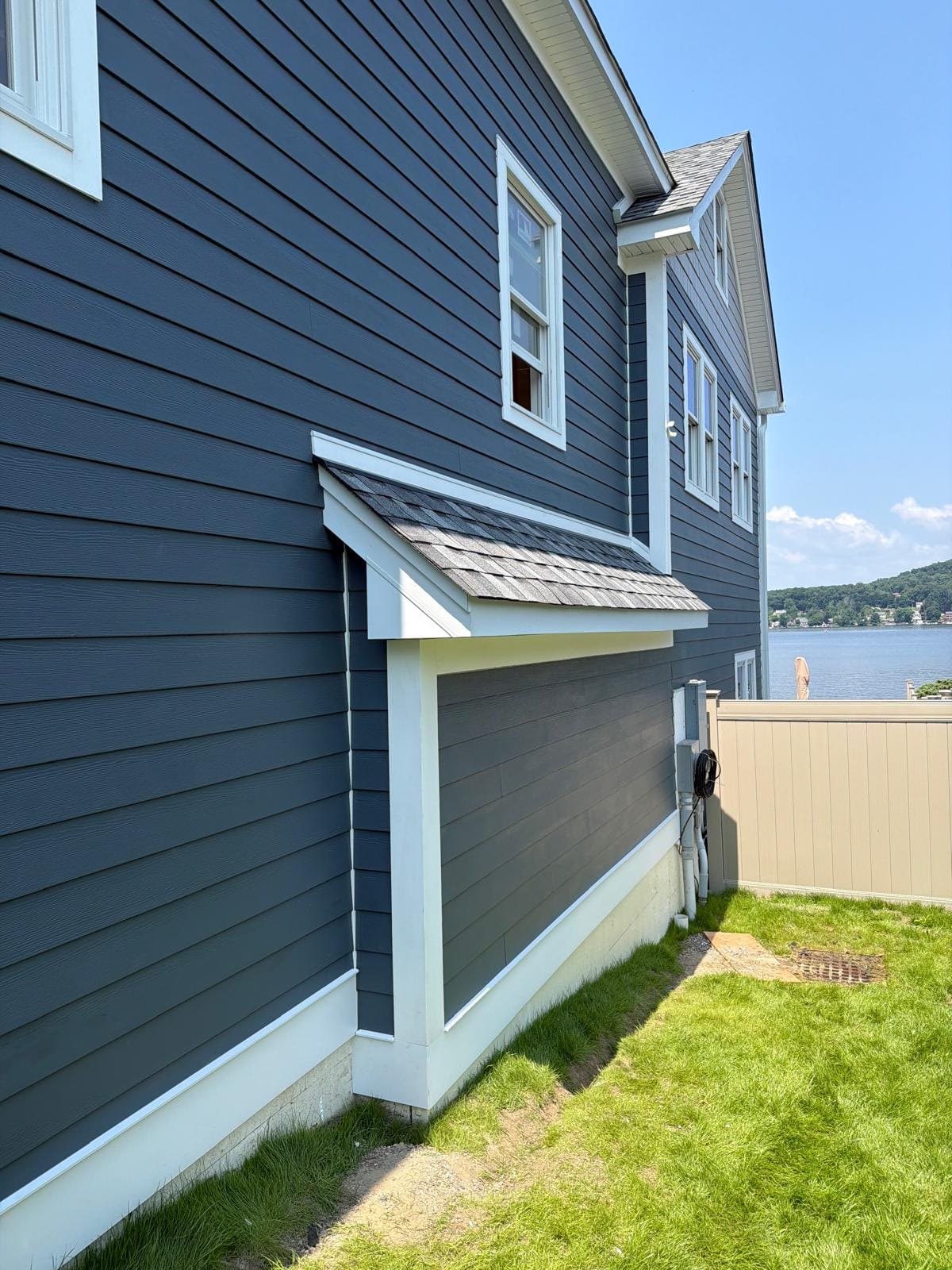 Finished navy lap side elevation with a shed-roof pent over a bay window