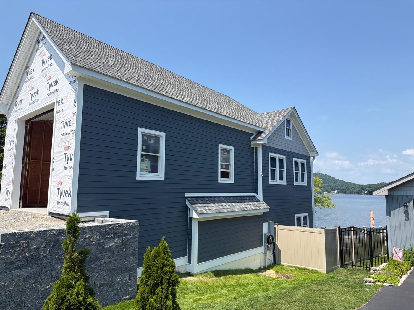 Three-quarter street view of the finished navy home beside the lake