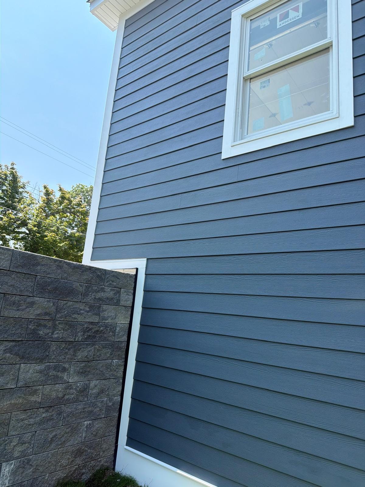 Close-up of navy HardiePlank lap coursing and white corner trim