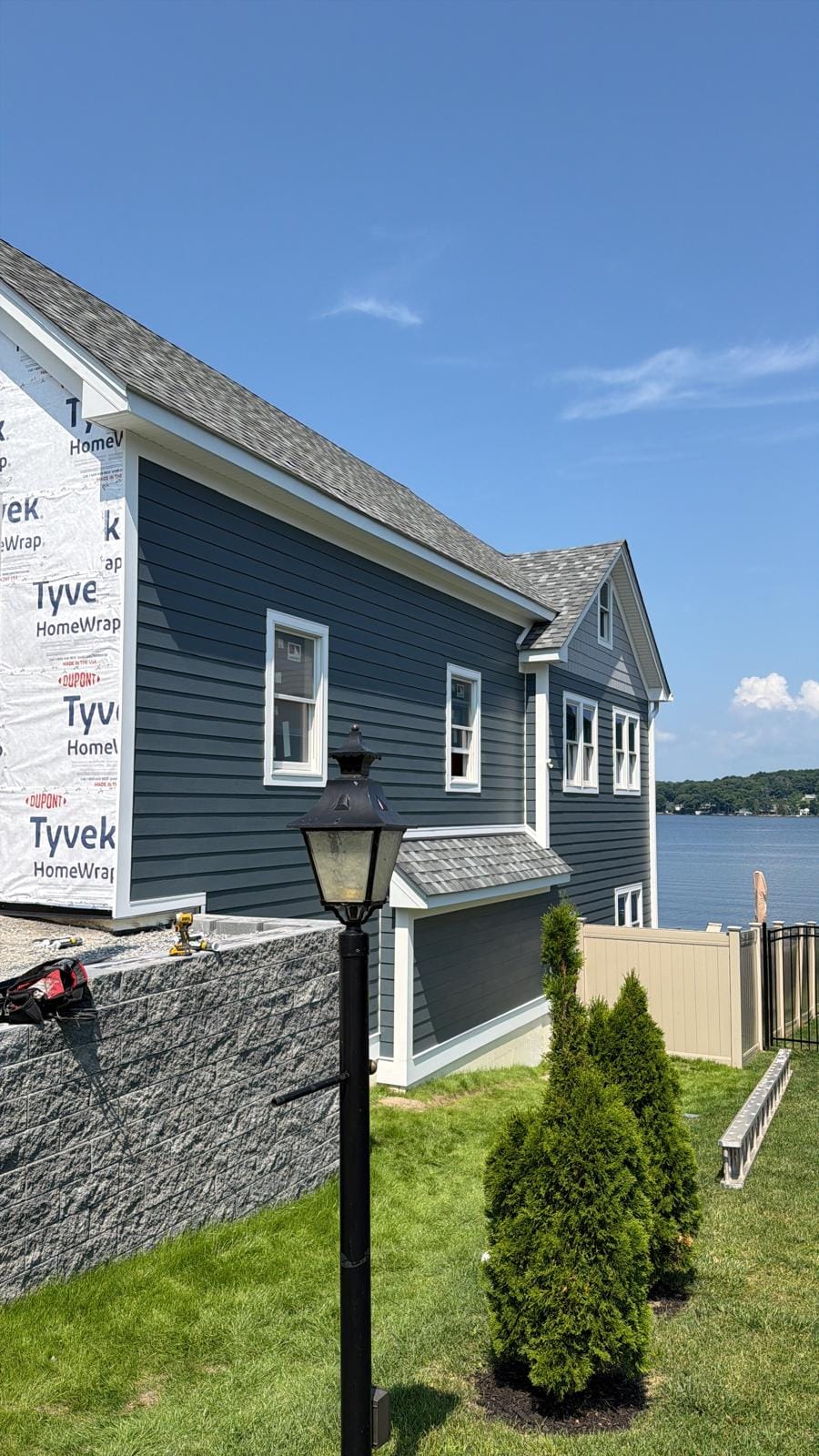 Near-finished navy lap side elevation with a landscaped lawn