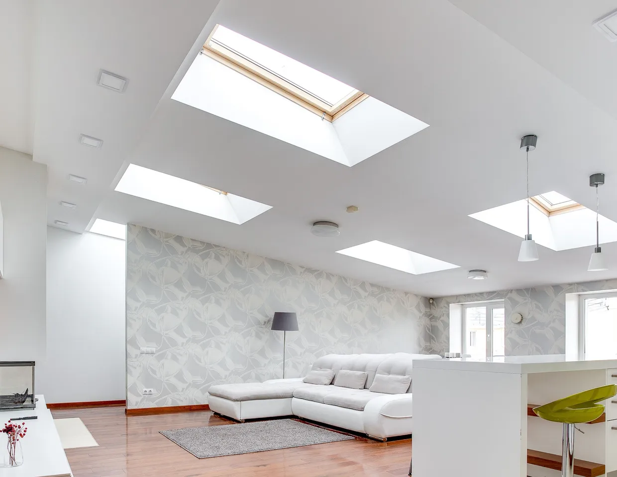 Bright open-plan living room lit from above by four roof skylights set into a vaulted ceiling